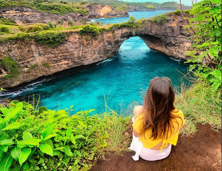 Shot of a gir sitting in front of Angel's Billabong in Nusa Penida Island