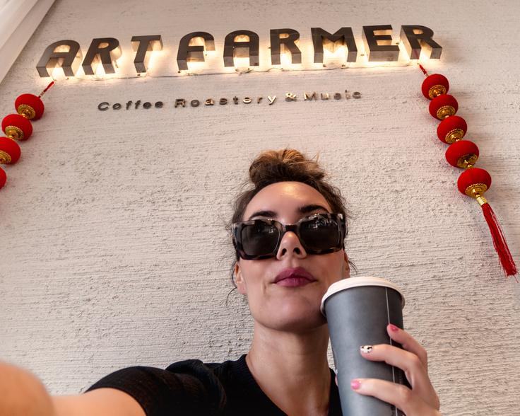 Girl sipping capuccino in a take away cup from a popular cafe in Chiang Mai city