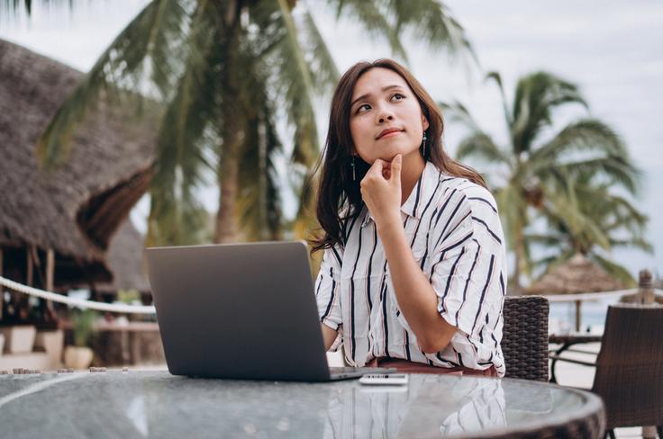 Shot of a girl working on her laptop in Bali