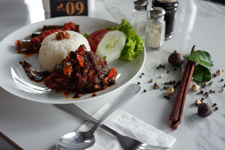 Shot of beef rendang with plain rice and chillies showcasing its origins