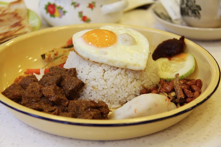 Shot of a beef rendang dish next to plain rice and fried egg