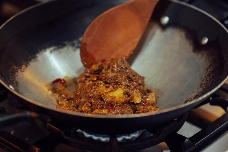 Shot of a rendang paste in a pot with strong fire underneath