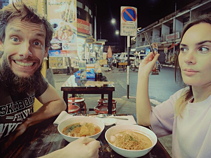 Man and girl eating a bowl of Khao Soi in Chiang Mai, Thailand