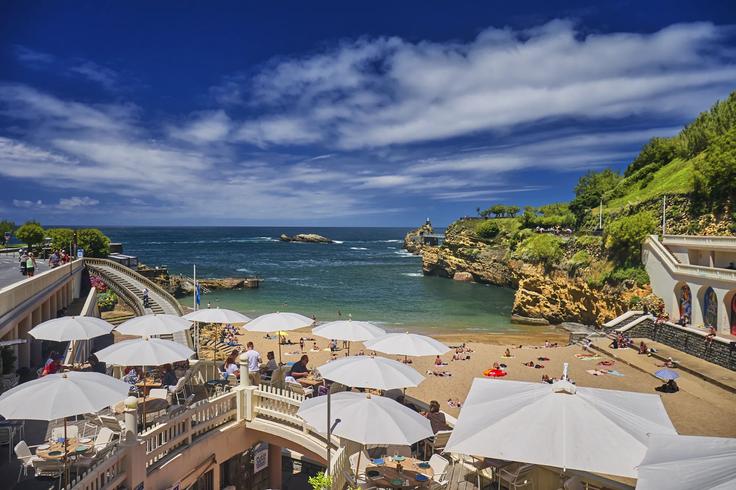 Viby white umbrellas close to the shore in the main beach where people enjoy amazing food with a seabreeze