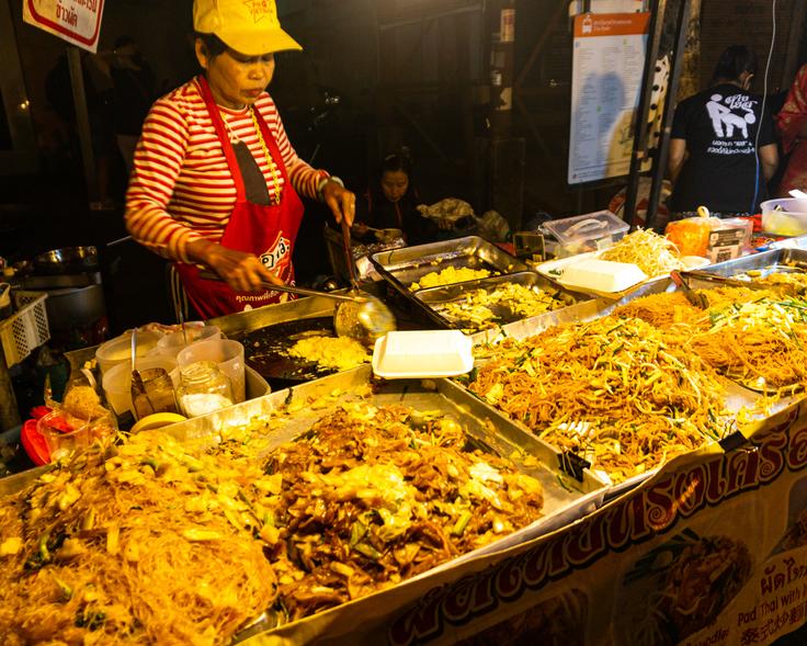 Street food scene in Chiang Mai with a variety of mouthwatering dishes, including flavorful noodles and tempting fried rice