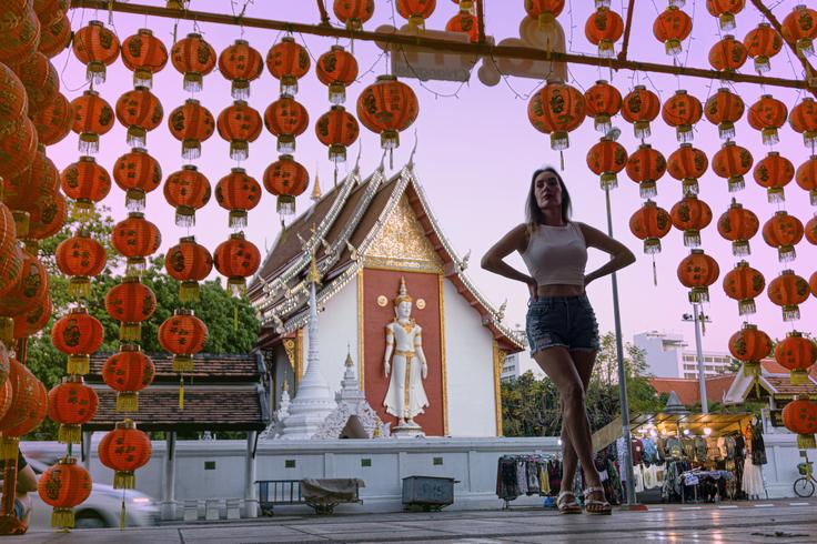 Girl posing in front of a temple in Chiang Mai surrounded by Chinese red lights