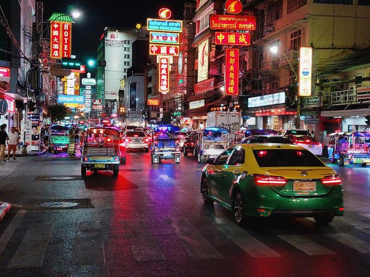 Shot at night showing Chinatown Bangkok with the typical Chinese lights on and tuktuks on the road