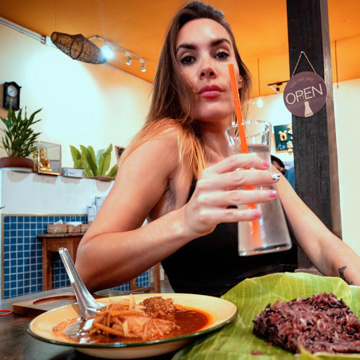 Girl eating a Northern Thai chicken curry dish