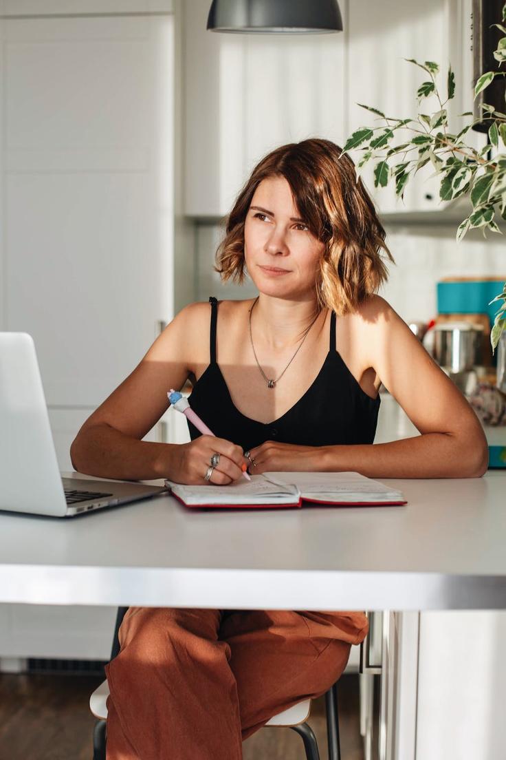 Shot of a girl Digital Nomad taking note about budget