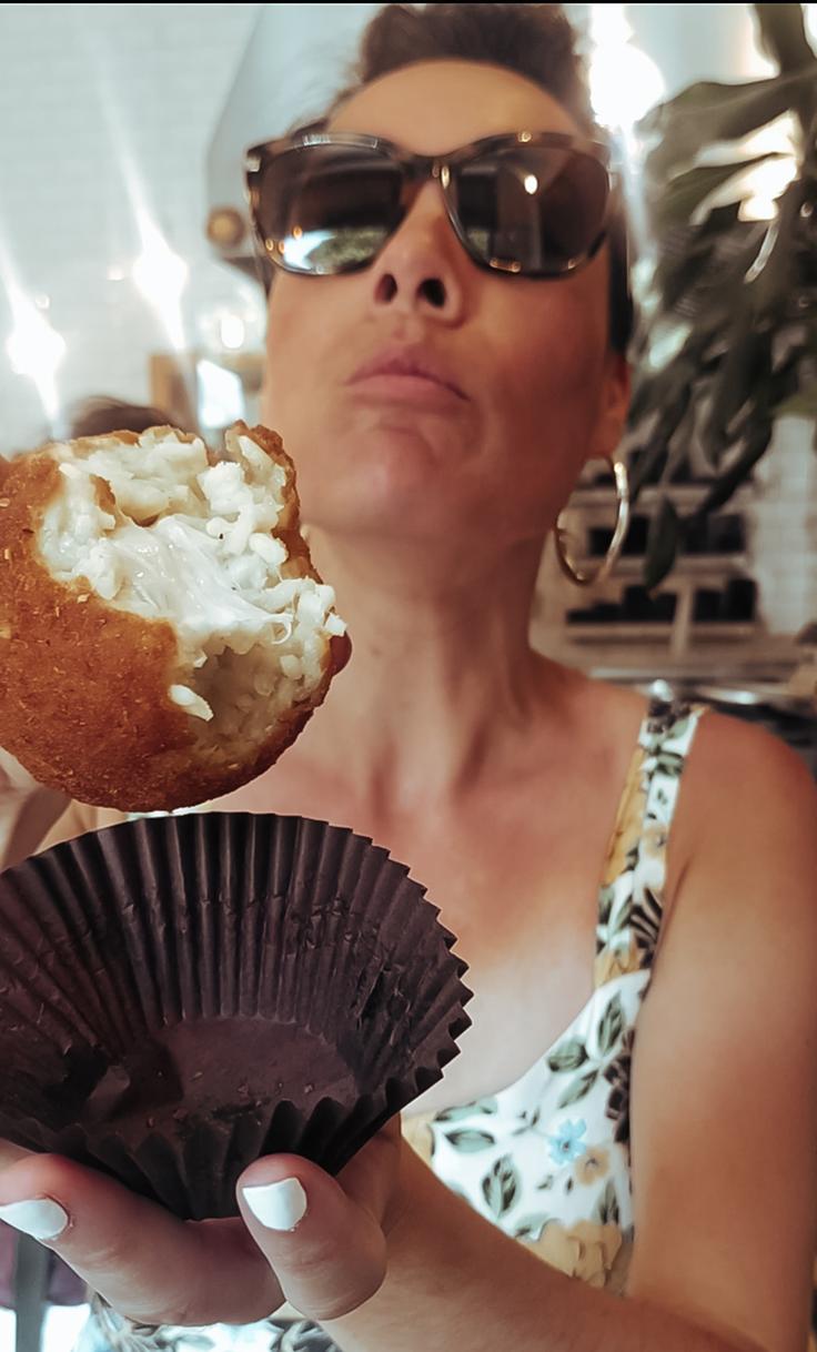 Girl eating a four cheese deep fried Arancini