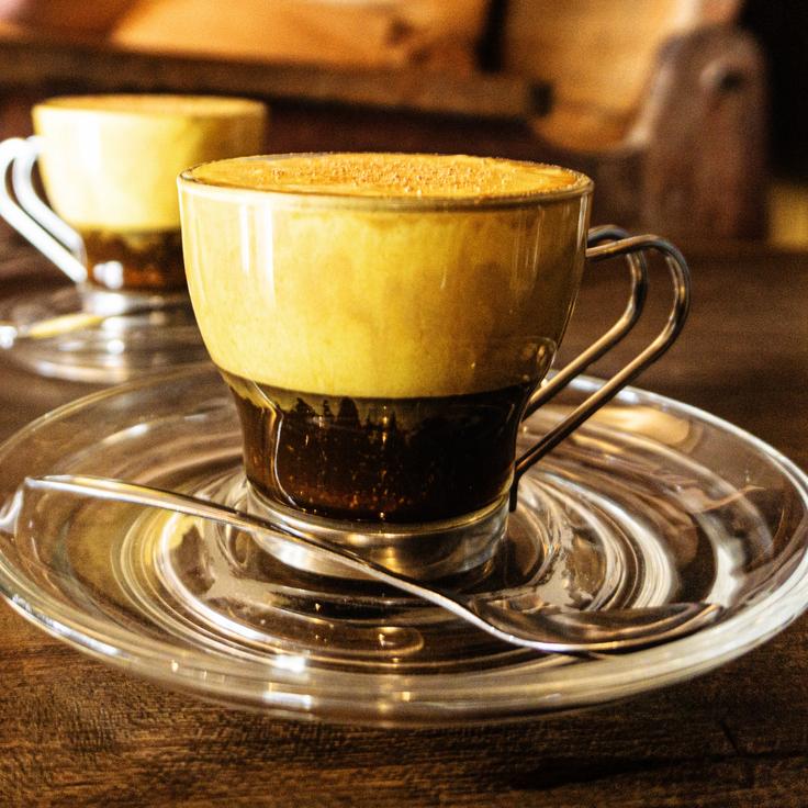 Photo of an egg coffee showcasing a glass with a espresso shot and a thick cream layer