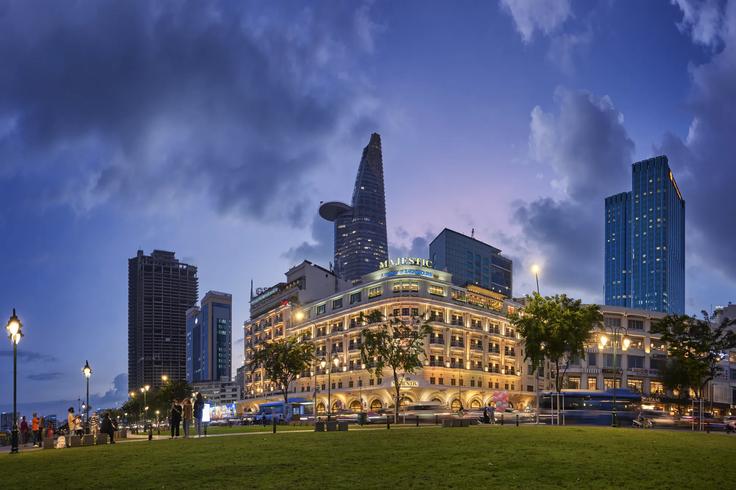 Building with lights on at night by the river of Saigon