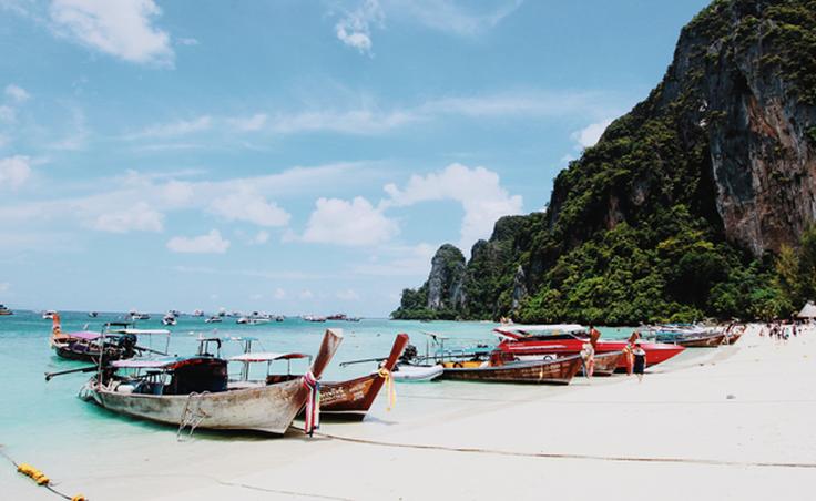 Frontal shot of a Phi Phi islands in Thailand with long tail boats on the sand