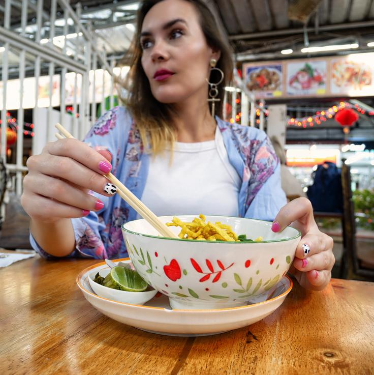 Girl eating Khao Soi, typical dish in Chiang Mai