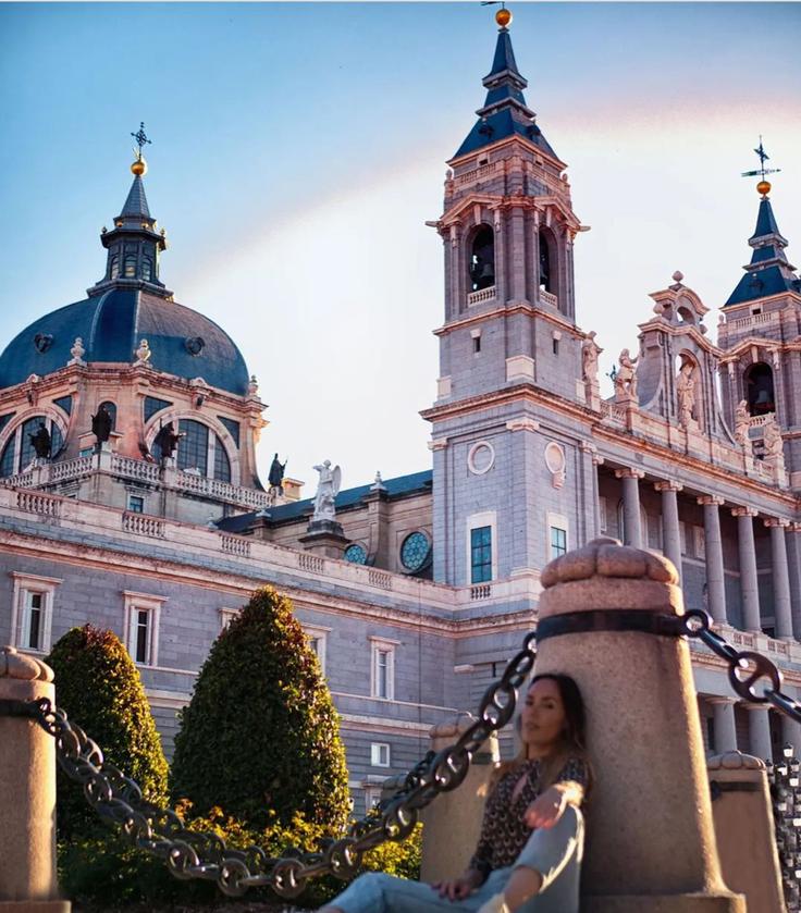 Shot of a girl sitting down in front of the Almudena Cathedral in Madrid