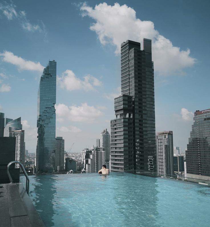 Shot of a guy swimming in the pool of a mid-range hotel in Bangkok