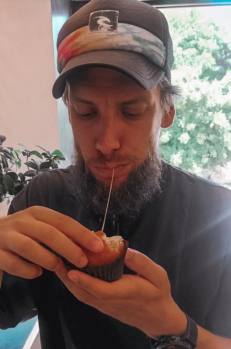 Man eating a mozzarella and prosciuto deep fried Arancini