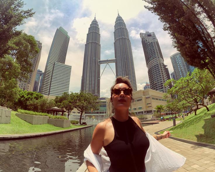 Shot of a girl posing in front of the Petrona towers in Kuala Lumpur