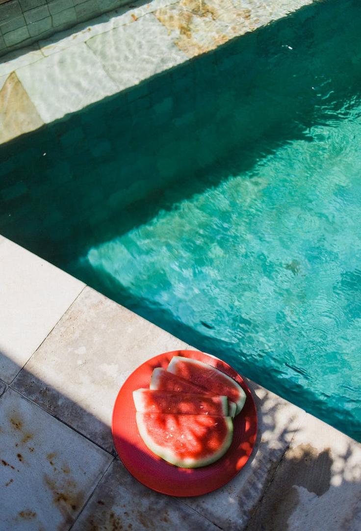 Shot of a swimming-pool in a hotel in Thailand with a plate of watermelon next to it