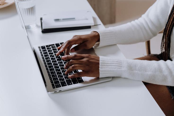 Shot of a girl typing in a laptop to show the digital nomad life