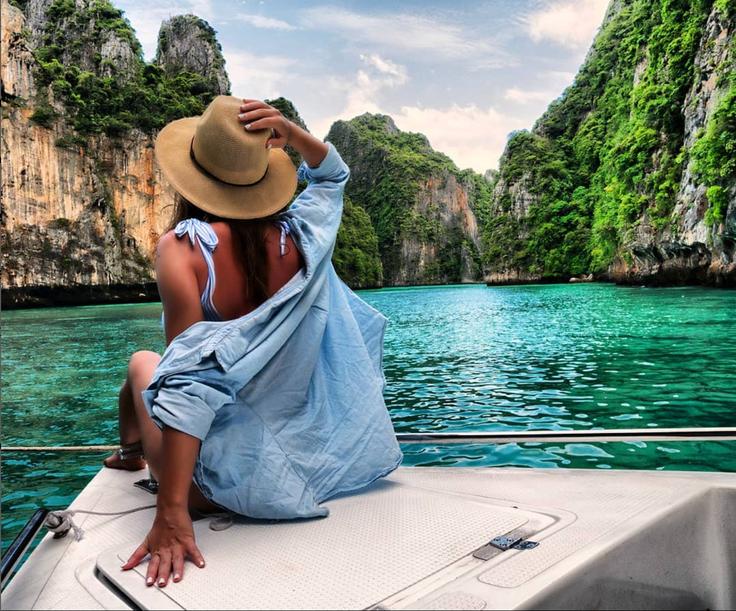 Shot of a girl sitting at the front of a long tail boat in Phuket beach