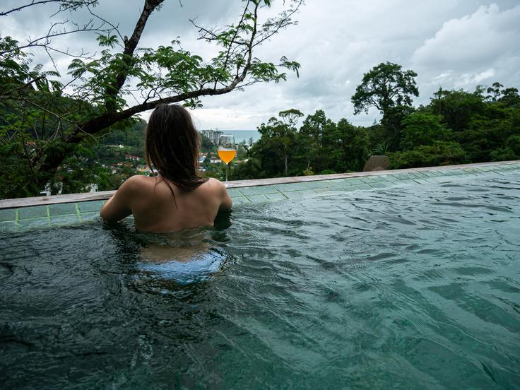 Shot of a girl in the infinity pool in a luxury villa in Thailand