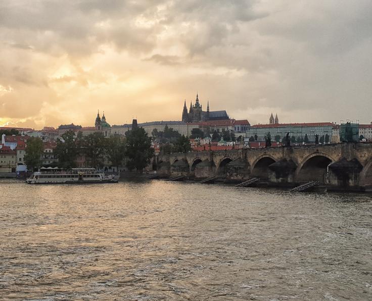 Shot of Prague at sunset from the river area against the Charles Bridge