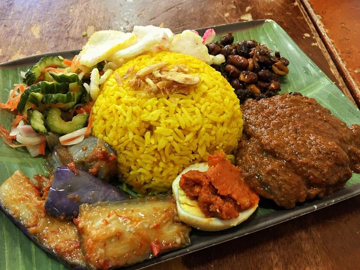 Shot of a beef rendang dish over rice and vegetables