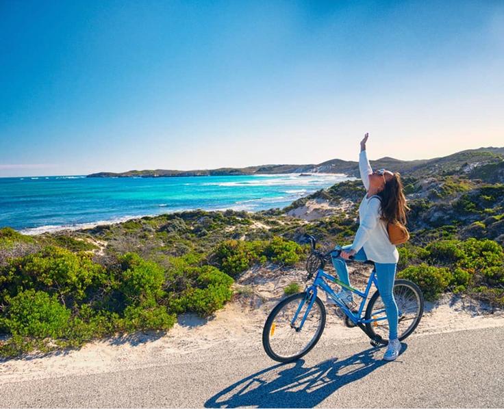 Shot of a girl riding a bike in Rottnest Island, Perth