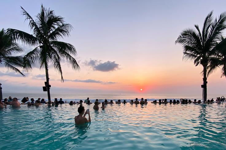 A serene poolside view at a beach club in Seminyak, Bali, offering a peaceful atmosphere to unwind and experience the beauty of a Bali sunset