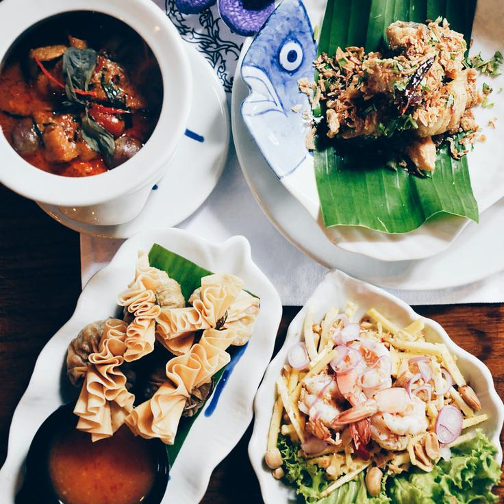 Shot of a table with four Thai dishes including deep fried wantons