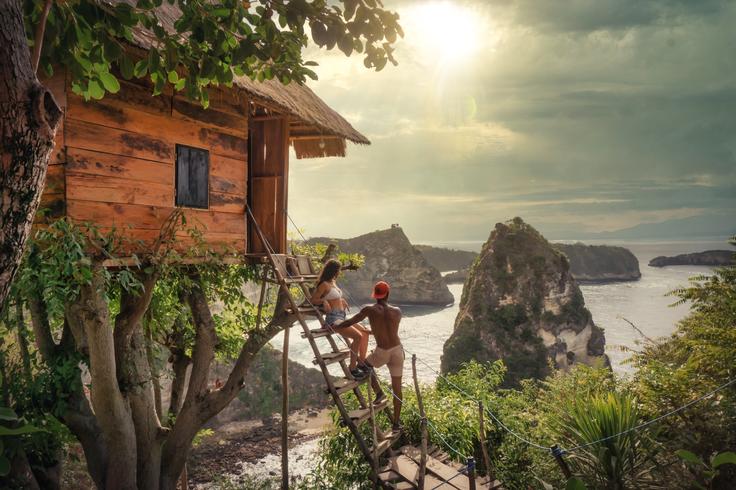 Shot of a couple in the ladder of the Rumah Pohon Tree House in Nusa Penida Island