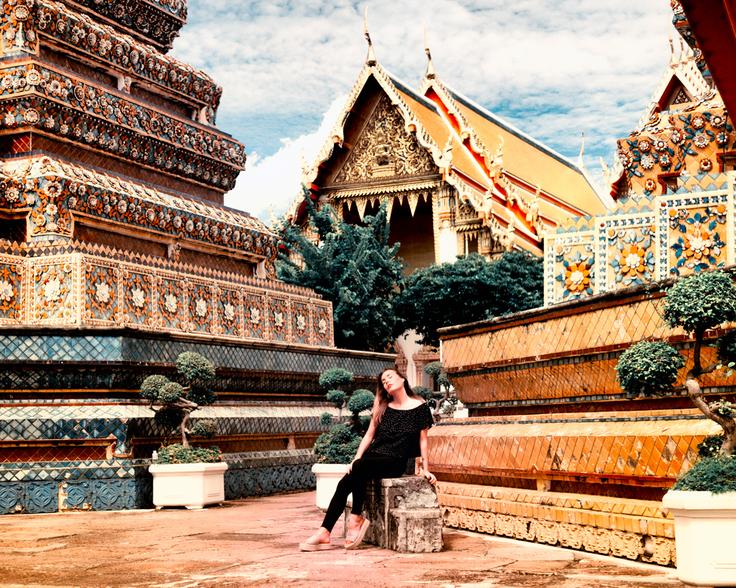 Girl sitting next to the Wat Pho Bangkok in Thailand