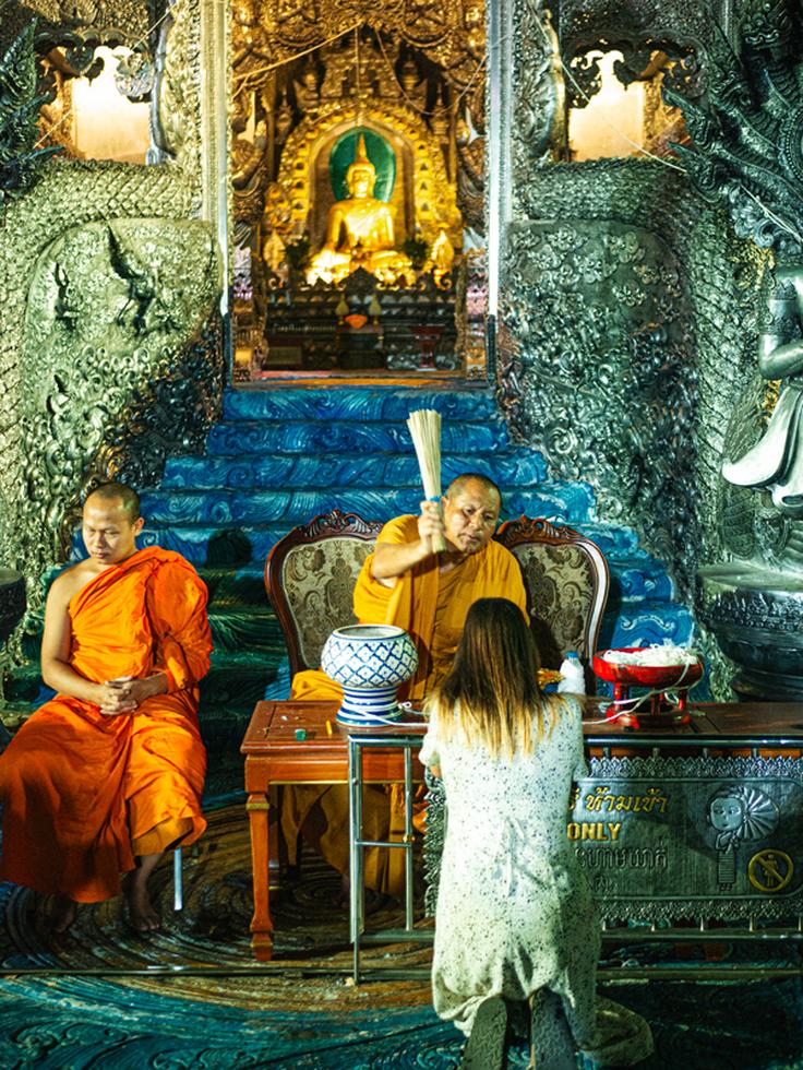 Shot of a girl receiving a blessing from the chief monk