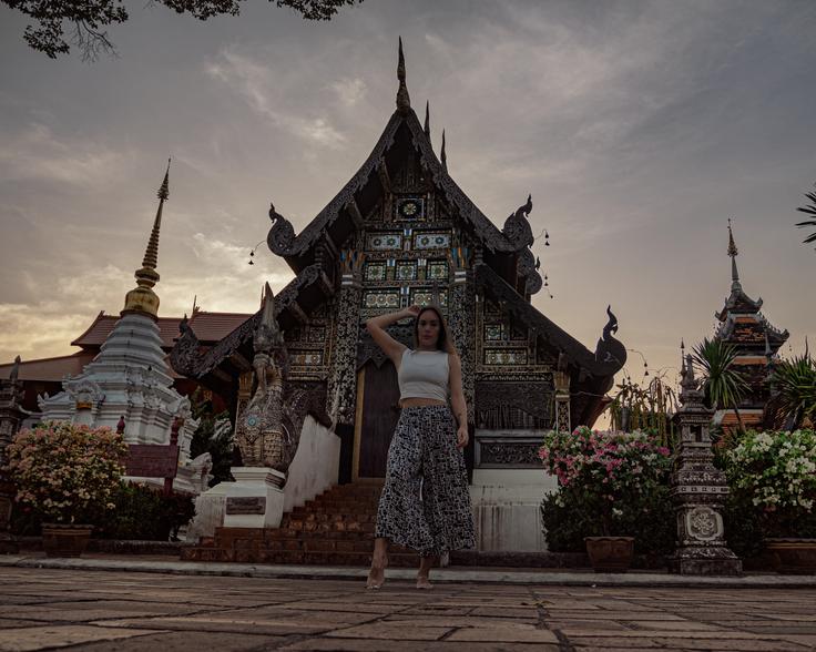 Girl posing in front of the side part of Wat Chedi Luang temple in Chiang Mai