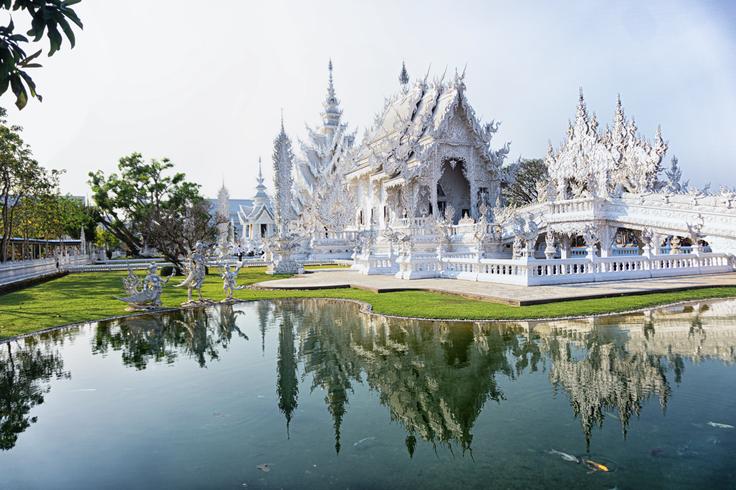 Photo of the Chiang Rai's White temple with its reflection on the surrounding lake