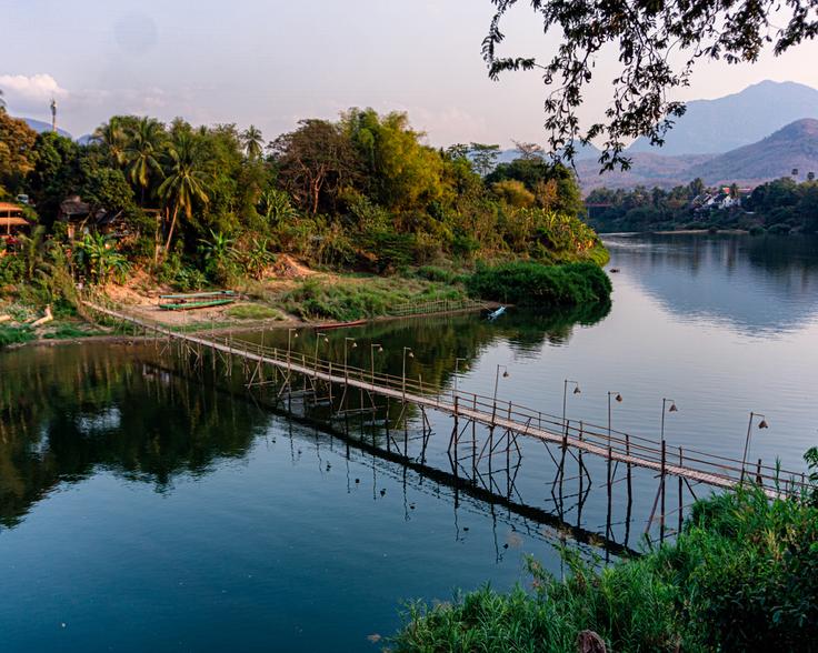 Shot at sunrise of a wood bridge next to the river in Luang Prabang, Laos